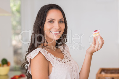 Beautiful brunette holding mini cupcake