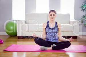 Fit woman doing yoga on mat