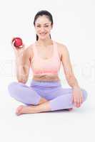 Pretty brunette looking at camera and holding red apple