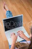 Attractive brunette sitting on the floor using her laptop