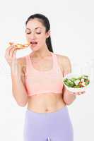 Pretty brunette eating pizza and holding salad