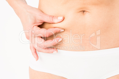 Fit woman pinching her stomach
