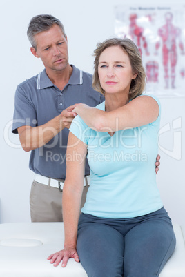 Woman stretching her arm with her doctor