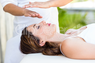 Calm woman receiving reiki treatment