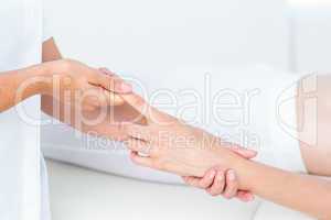 Physiotherapist pulling her patients finger