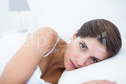 Pretty woman lying in her bed looking at camera