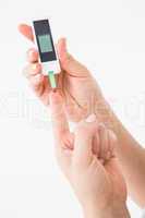 Diabetic woman using blood glucose monitor