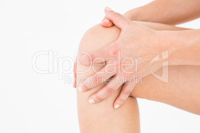 Natural woman touching her painful knee