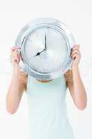 Woman holding clock in front of her head