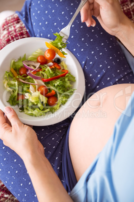 Pregnant woman eating a salad