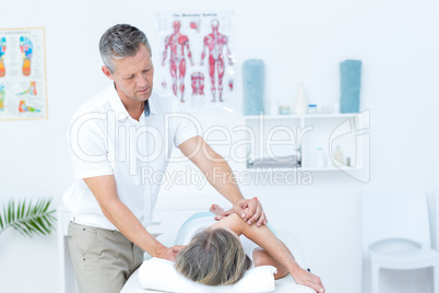 Physiotherapist doing back massage to his patient