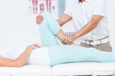 Doctor stretching his patients leg