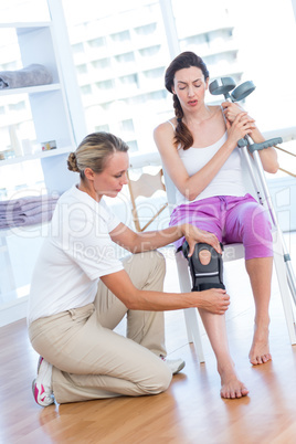Doctor examining her patients knee