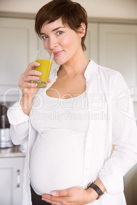 Pregnant woman drinking glass of orange juice
