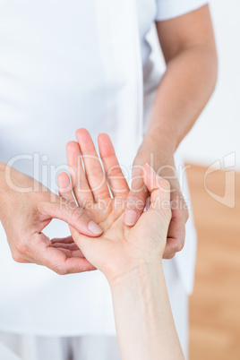 Physiotherapist examining her patients hand