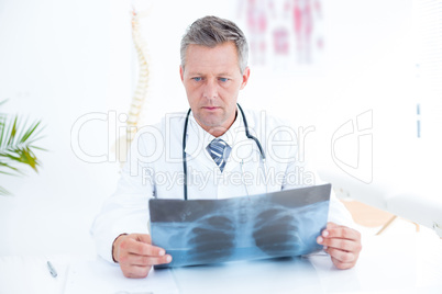 Thoughtful doctor holding xray
