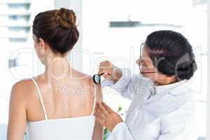 Doctor examining patient with magnifying glass