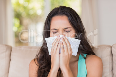 Pretty brunette blowing her nose