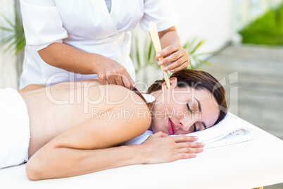 Relaxed brunette getting an ear candling treatment