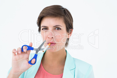 Pretty brunette cutting a cigarette