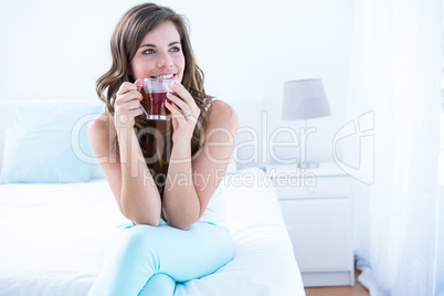 Thoughtful woman drinking a cup of tea
