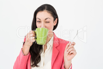 Smiling brunette drinking hot beverage