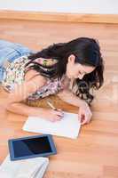 Pretty brunette writing on a paper