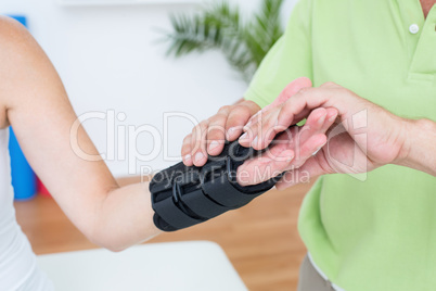 Doctor examining his patients wrist