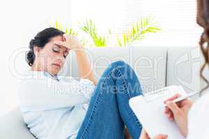 Therapist listening her patient and taking notes