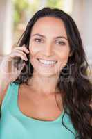 Pretty brunette calling with her mobile phone