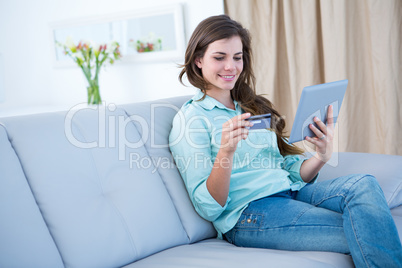 Pretty brunette doing online shopping with her tablet pc