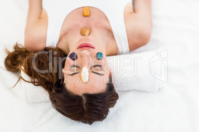 Relaxed brunette lying on mat with stones