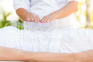 Calm woman receiving reiki treatment