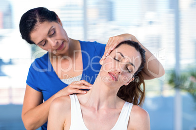 Therapist examining her patients neck