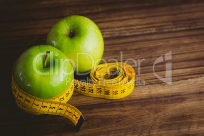 Green apples with measuring tape