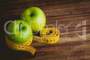 Green apples with measuring tape