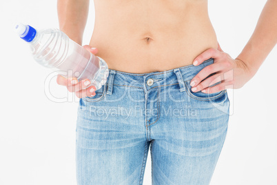 Fit woman standing with bottle of water