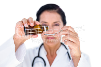 Confident female doctor pouring syrup in a spoon