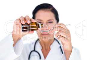 Confident female doctor pouring syrup in a spoon