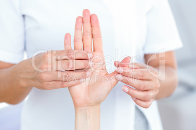 Physiotherapist examining her patients hand