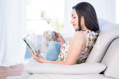 Pretty brunette reading on couch