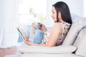 Pretty brunette reading on couch