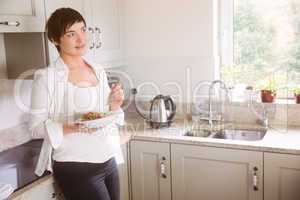 Pregnant woman having bowl of salad