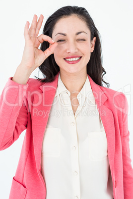 Smiling brunette doing okay sign and winking