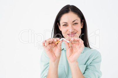 Smiling woman snapping cigarette in half