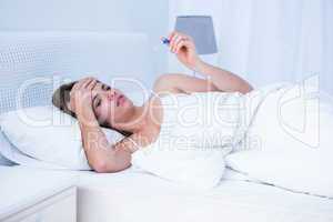 Sick woman looking at her thermometer