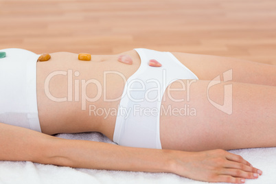 Relaxed brunette lying on mat with stones