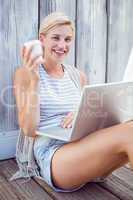 Pretty blonde woman using her laptop and drinking coffee