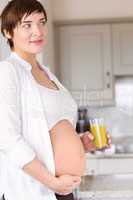 Pregnant woman drinking glass of orange juice