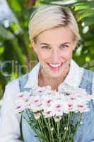Pretty blonde woman holding bunch of flowers